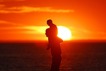 A father and his child enjoying the sunset over Lake Ontario, Ontario, Canada