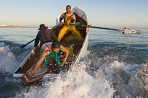 Small-scale fishers rowing the waves - image by Peter Chadwick